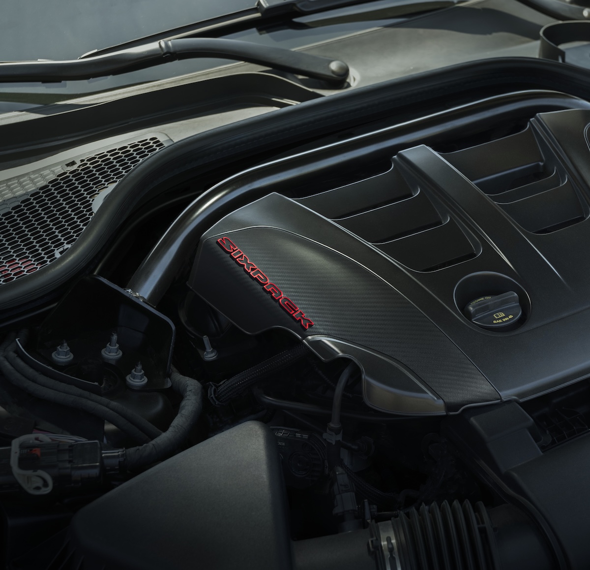 Sixpack Powered Dodge Charger Models Feature A Carbon Styled Engine Cover Stamped With A Red Accented Sixpack Text Logo That Announces The Presence Of The Internal Combustion Engine Under The Hood.