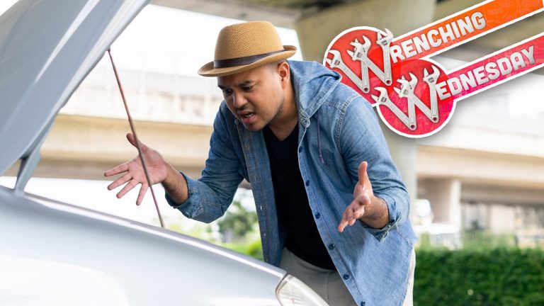 Frustrated Young Asian Man Looking At Broken Down Car Engine On