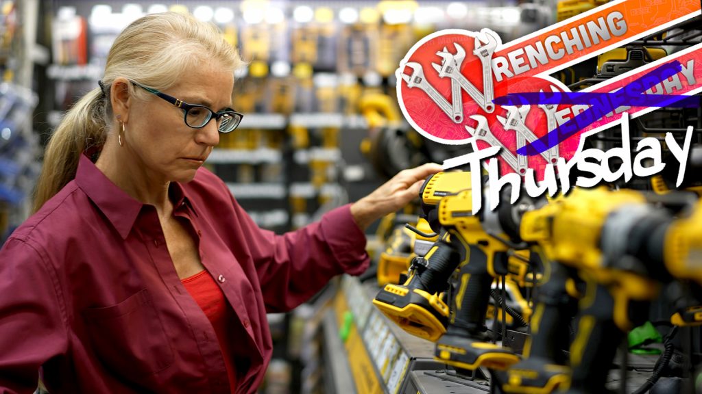 Mature Woman Looking At Cordless Drills And Power Tools At A Large Hardware Store.