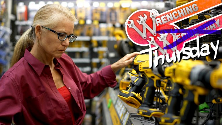 Mature Woman Looking At Cordless Drills And Power Tools At A Large Hardware Store.